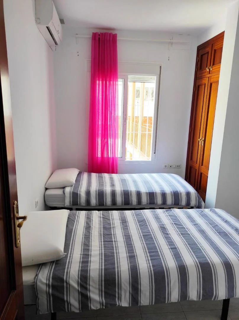 Dormitorio con dos camas junto a la ventana