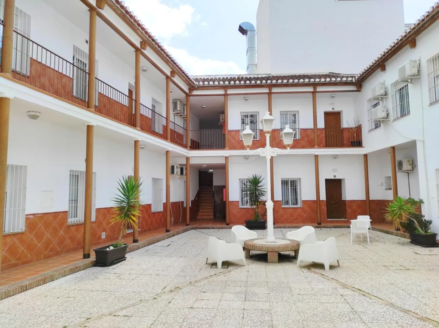Patio andaluz del edificio, con galerías blancas y farola