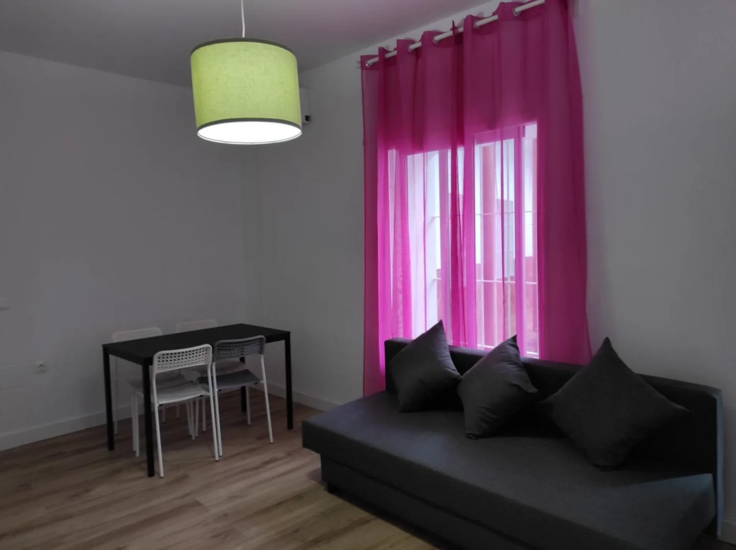 Salón con sofá, mesa de comedor y cortinas fucsia